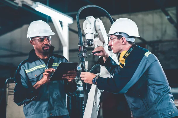 Operai che lavorano con braccio robotico esperto in un'officina — Foto Stock