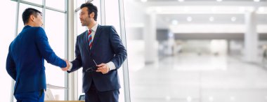 Business people handshake in corporate office in widen view