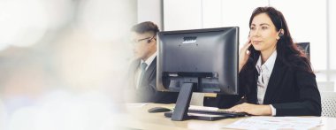 Ofiste çalışan kulaklık takan işadamları uzak müşteri ya da meslektaşlarını desteklemek için çalışıyorlar. Çağrı merkezi, tele pazarlama, müşteri destek acentesi geniş görünümde hizmet sunar .