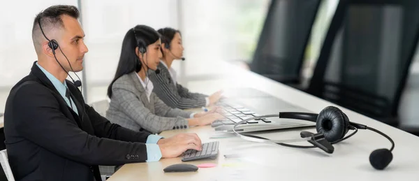 Zakenmensen die een headset dragen en op kantoor werken, verbreden het zicht — Stockfoto