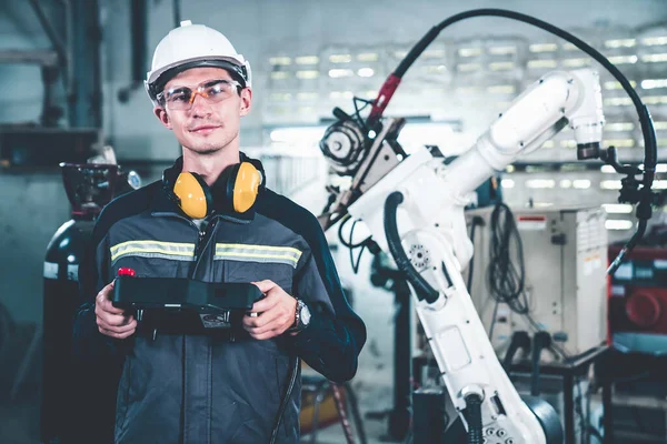 Young factory worker working with adept robotic arm