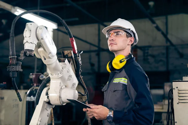 Fiatal Gyári Munkás Aki Robotkarokkal Dolgozik Egy Műhelyben Ipari Robot — Stock Fotó