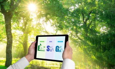Çevre tasarrufu ve ESG iş konsepti için yeşil iş dönüşümü. İşadamı, çevre dostu yönetime ve alternatif temiz enerji kullanımına yönelik kurumsal bir hedef belirlemek için tablet kullanıyor.