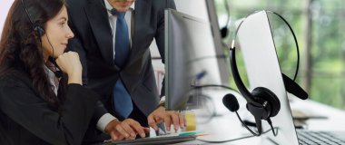 Ofiste çalışan kulaklık takan işadamları uzak müşteri ya da meslektaşlarını desteklemek için çalışıyorlar. Çağrı merkezi, tele pazarlama, müşteri destek acentesi geniş görünümde hizmet sunar .