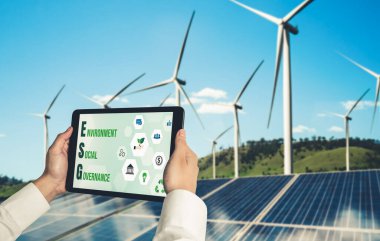 Çevre tasarrufu ve ESG iş konsepti için yeşil iş dönüşümü. İşadamı, çevre dostu yönetime ve alternatif temiz enerji kullanımına yönelik kurumsal bir hedef belirlemek için tablet kullanıyor.
