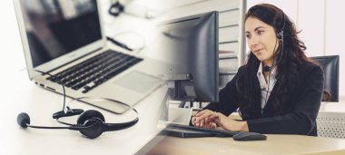 Ofiste çalışan kulaklık takan işadamları uzak müşteri ya da meslektaşlarını desteklemek için çalışıyorlar. Çağrı merkezi, tele pazarlama, müşteri destek acentesi geniş görünümde hizmet sunar .