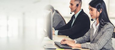 Ofiste çalışan kulaklık takan işadamları uzak müşteri ya da meslektaşlarını desteklemek için çalışıyorlar. Çağrı merkezi, tele pazarlama, müşteri destek acentesi geniş görünümde hizmet sunar .