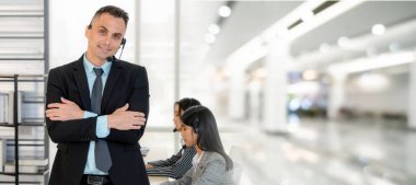 Ofiste çalışan kulaklık takan işadamları uzak müşteri ya da meslektaşlarını desteklemek için çalışıyorlar. Çağrı merkezi, tele pazarlama, müşteri destek acentesi geniş görünümde hizmet sunar .