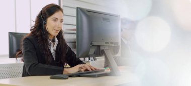 Ofiste çalışan kulaklık takan işadamları uzak müşteri ya da meslektaşlarını desteklemek için çalışıyorlar. Çağrı merkezi, tele pazarlama, müşteri destek acentesi geniş görünümde hizmet sunar .