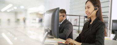 Ofiste çalışan kulaklık takan işadamları uzak müşteri ya da meslektaşlarını desteklemek için çalışıyorlar. Çağrı merkezi, tele pazarlama, müşteri destek acentesi geniş görünümde hizmet sunar .