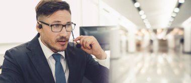 Ofiste çalışan kulaklık takan işadamları uzak müşteri ya da meslektaşlarını desteklemek için çalışıyorlar. Çağrı merkezi, tele pazarlama, müşteri destek acentesi geniş görünümde hizmet sunar .