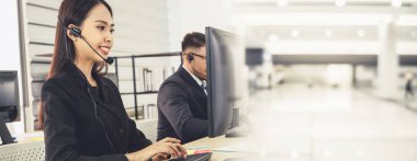 Ofiste çalışan kulaklık takan işadamları uzak müşteri ya da meslektaşlarını desteklemek için çalışıyorlar. Çağrı merkezi, tele pazarlama, müşteri destek acentesi geniş görünümde hizmet sunar .