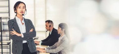 Ofiste çalışan kulaklık takan işadamları uzak müşteri ya da meslektaşlarını desteklemek için çalışıyorlar. Çağrı merkezi, tele pazarlama, müşteri destek acentesi geniş görünümde hizmet sunar .