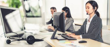 Ofiste çalışan kulaklık takan işadamları uzak müşteri ya da meslektaşlarını desteklemek için çalışıyorlar. Çağrı merkezi, tele pazarlama, müşteri destek acentesi geniş görünümde hizmet sunar .
