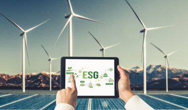 Çevre tasarrufu ve ESG iş konsepti için yeşil iş dönüşümü. İşadamı, çevre dostu yönetime ve alternatif temiz enerji kullanımına yönelik kurumsal bir hedef belirlemek için tablet kullanıyor.