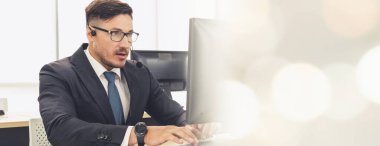 Ofiste çalışan kulaklık takan işadamları uzak müşteri ya da meslektaşlarını desteklemek için çalışıyorlar. Çağrı merkezi, tele pazarlama, müşteri destek acentesi geniş görünümde hizmet sunar .