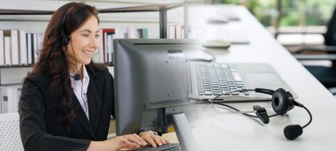 Ofiste çalışan kulaklık takan işadamları uzak müşteri ya da meslektaşlarını desteklemek için çalışıyorlar. Çağrı merkezi, tele pazarlama, müşteri destek acentesi geniş görünümde hizmet sunar .