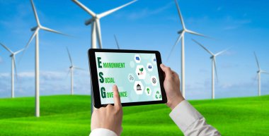 Çevre tasarrufu ve ESG iş konsepti için yeşil iş dönüşümü. İşadamı, çevre dostu yönetime ve alternatif temiz enerji kullanımına yönelik kurumsal bir hedef belirlemek için tablet kullanıyor.