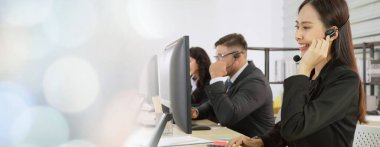 Ofiste çalışan kulaklık takan işadamları uzak müşteri ya da meslektaşlarını desteklemek için çalışıyorlar. Çağrı merkezi, tele pazarlama, müşteri destek acentesi geniş görünümde hizmet sunar .