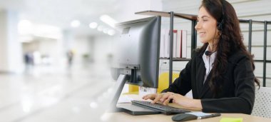 Ofiste çalışan kulaklık takan işadamları uzak müşteri ya da meslektaşlarını desteklemek için çalışıyorlar. Çağrı merkezi, tele pazarlama, müşteri destek acentesi geniş görünümde hizmet sunar .