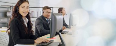 Ofiste çalışan kulaklık takan işadamları uzak müşteri ya da meslektaşlarını desteklemek için çalışıyorlar. Çağrı merkezi, tele pazarlama, müşteri destek acentesi geniş görünümde hizmet sunar .