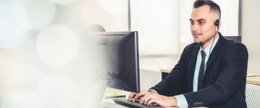 Ofiste çalışan kulaklık takan işadamları uzak müşteri ya da meslektaşlarını desteklemek için çalışıyorlar. Çağrı merkezi, tele pazarlama, müşteri destek acentesi geniş görünümde hizmet sunar .