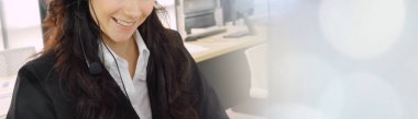 Geniş görünüm panorama panorama pankartındaki çağrı merkezi ya da müşteri destek ajansı, telefon konferansında uzak müşteri ya da iş arkadaşını desteklemek için ofiste çalışırken kulaklık takıyor.