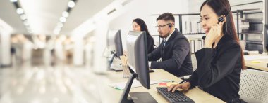 Ofiste çalışan kulaklık takan işadamları uzak müşteri ya da meslektaşlarını desteklemek için çalışıyorlar. Çağrı merkezi, tele pazarlama, müşteri destek acentesi geniş görünümde hizmet sunar .