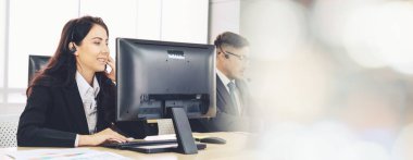 Ofiste çalışan kulaklık takan işadamları uzak müşteri ya da meslektaşlarını desteklemek için çalışıyorlar. Çağrı merkezi, tele pazarlama, müşteri destek acentesi geniş görünümde hizmet sunar .