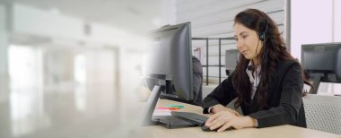 Ofiste çalışan kulaklık takan işadamları uzak müşteri ya da meslektaşlarını desteklemek için çalışıyorlar. Çağrı merkezi, tele pazarlama, müşteri destek acentesi geniş görünümde hizmet sunar .