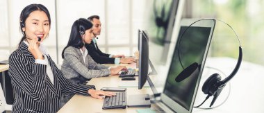 Ofiste çalışan kulaklık takan işadamları uzak müşteri ya da meslektaşlarını desteklemek için çalışıyorlar. Çağrı merkezi, tele pazarlama, müşteri destek acentesi geniş görünümde hizmet sunar .
