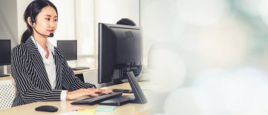 Ofiste çalışan kulaklık takan işadamları uzak müşteri ya da meslektaşlarını desteklemek için çalışıyorlar. Çağrı merkezi, tele pazarlama, müşteri destek acentesi geniş görünümde hizmet sunar .