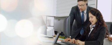 Ofiste çalışan kulaklık takan işadamları uzak müşteri ya da meslektaşlarını desteklemek için çalışıyorlar. Çağrı merkezi, tele pazarlama, müşteri destek acentesi geniş görünümde hizmet sunar .