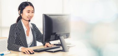 Ofiste çalışan kulaklık takan işadamları uzak müşteri ya da meslektaşlarını desteklemek için çalışıyorlar. Çağrı merkezi, tele pazarlama, müşteri destek acentesi geniş görünümde hizmet sunar .