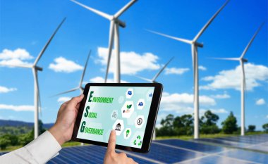 Çevre tasarrufu ve ESG iş konsepti için yeşil iş dönüşümü. İşadamı, çevre dostu yönetime ve alternatif temiz enerji kullanımına yönelik kurumsal bir hedef belirlemek için tablet kullanıyor.