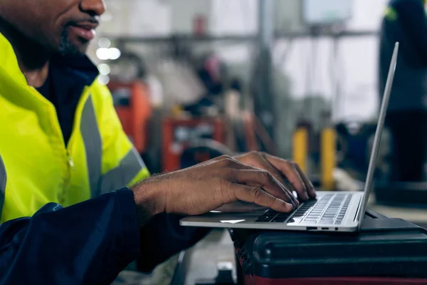 Factory worker working with laptop computer to do adept procedure checklist . Factory production line operator occupation quality control concept .