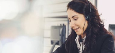 Ofiste çalışan kulaklık takan işadamları uzak müşteri ya da meslektaşlarını desteklemek için çalışıyorlar. Çağrı merkezi, tele pazarlama, müşteri destek acentesi geniş görünümde hizmet sunar .