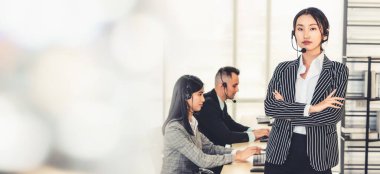 Ofiste çalışan kulaklık takan işadamları uzak müşteri ya da meslektaşlarını desteklemek için çalışıyorlar. Çağrı merkezi, tele pazarlama, müşteri destek acentesi geniş görünümde hizmet sunar .