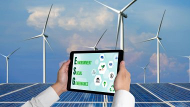 Çevre tasarrufu ve ESG iş konsepti için yeşil iş dönüşümü. İşadamı, çevre dostu yönetime ve alternatif temiz enerji kullanımına yönelik kurumsal bir hedef belirlemek için tablet kullanıyor.