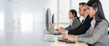 Ofiste çalışan kulaklık takan işadamları uzak müşteri ya da meslektaşlarını desteklemek için çalışıyorlar. Çağrı merkezi, tele pazarlama, müşteri destek acentesi geniş görünümde hizmet sunar .