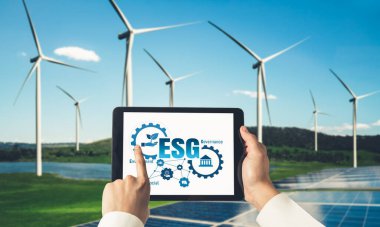 Çevre tasarrufu ve ESG iş konsepti için yeşil iş dönüşümü. İşadamı, çevre dostu yönetime ve alternatif temiz enerji kullanımına yönelik kurumsal bir hedef belirlemek için tablet kullanıyor.