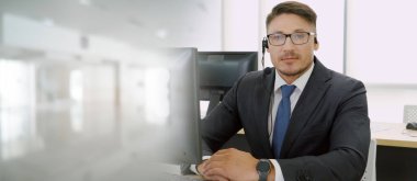 Ofiste çalışan kulaklık takan işadamları uzak müşteri ya da meslektaşlarını desteklemek için çalışıyorlar. Çağrı merkezi, tele pazarlama, müşteri destek acentesi geniş görünümde hizmet sunar .