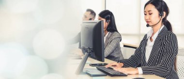 Ofiste çalışan kulaklık takan işadamları uzak müşteri ya da meslektaşlarını desteklemek için çalışıyorlar. Çağrı merkezi, tele pazarlama, müşteri destek acentesi geniş görünümde hizmet sunar .