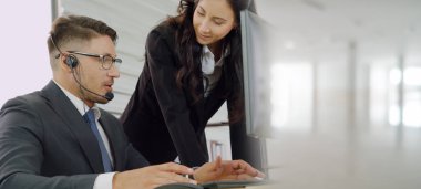 Ofiste çalışan kulaklık takan işadamları uzak müşteri ya da meslektaşlarını desteklemek için çalışıyorlar. Çağrı merkezi, tele pazarlama, müşteri destek acentesi geniş görünümde hizmet sunar .