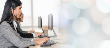 Ofiste çalışan kulaklık takan işadamları uzak müşteri ya da meslektaşlarını desteklemek için çalışıyorlar. Çağrı merkezi, tele pazarlama, müşteri destek acentesi geniş görünümde hizmet sunar .