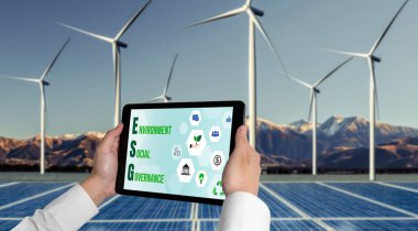 Çevre tasarrufu ve ESG iş konsepti için yeşil iş dönüşümü. İşadamı, çevre dostu yönetime ve alternatif temiz enerji kullanımına yönelik kurumsal bir hedef belirlemek için tablet kullanıyor.