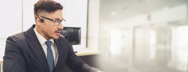 Ofiste çalışan kulaklık takan işadamları uzak müşteri ya da meslektaşlarını desteklemek için çalışıyorlar. Çağrı merkezi, tele pazarlama, müşteri destek acentesi geniş görünümde hizmet sunar .