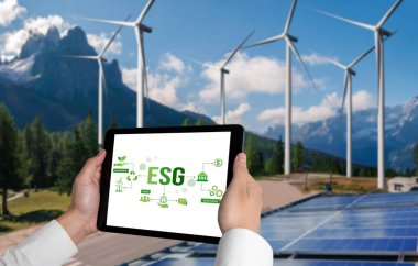 Çevre tasarrufu ve ESG iş konsepti için yeşil iş dönüşümü. İşadamı, çevre dostu yönetime ve alternatif temiz enerji kullanımına yönelik kurumsal bir hedef belirlemek için tablet kullanıyor.
