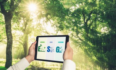 Çevre tasarrufu ve ESG iş konsepti için yeşil iş dönüşümü. İşadamı, çevre dostu yönetime ve alternatif temiz enerji kullanımına yönelik kurumsal bir hedef belirlemek için tablet kullanıyor.