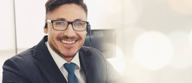 Ofiste çalışan kulaklık takan işadamları uzak müşteri ya da meslektaşlarını desteklemek için çalışıyorlar. Çağrı merkezi, tele pazarlama, müşteri destek acentesi geniş görünümde hizmet sunar .